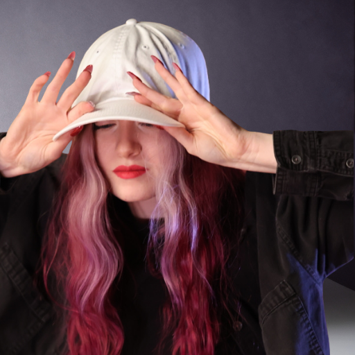 Woman wearing a white baseball cap that sits too low on a smaller head and presses toward her ears