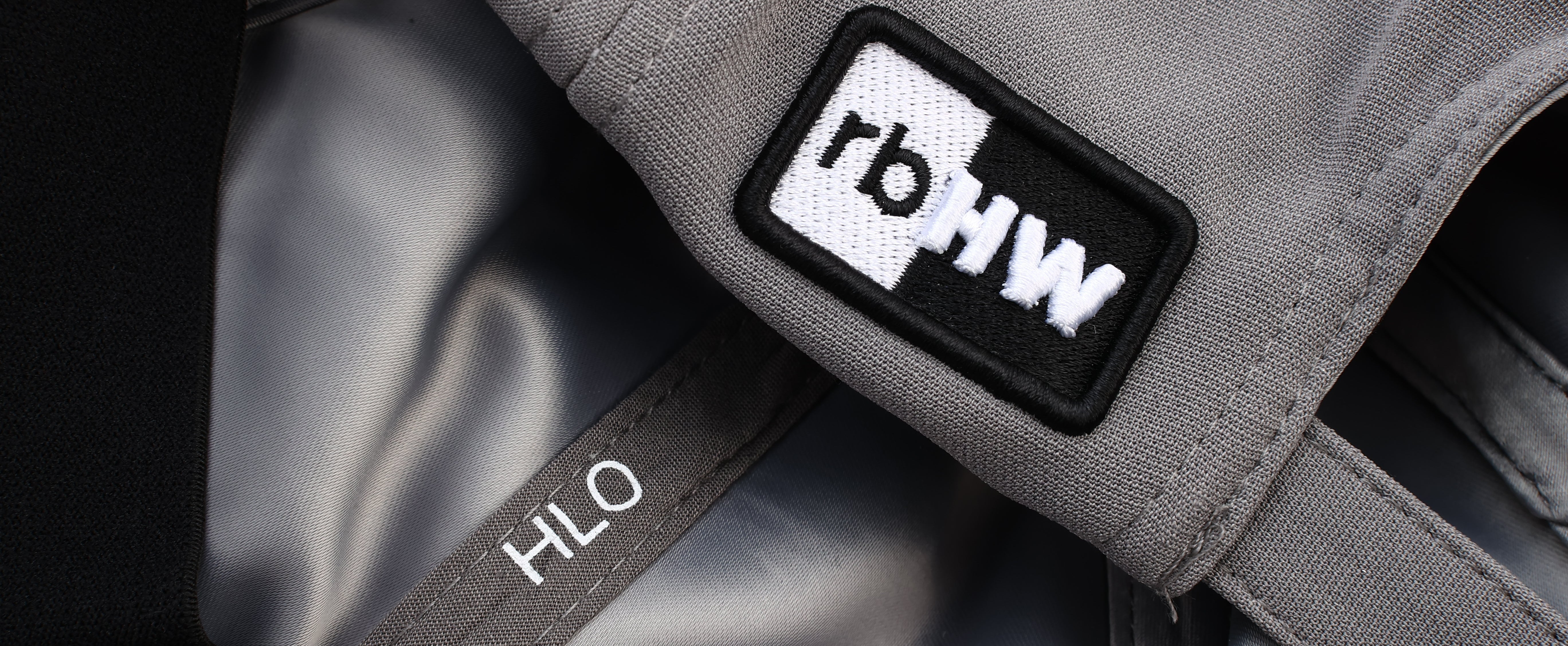 Close-up detail of the gray Rosebloom HLO showing the exterior logo patch and the smooth satin-lined interior.
