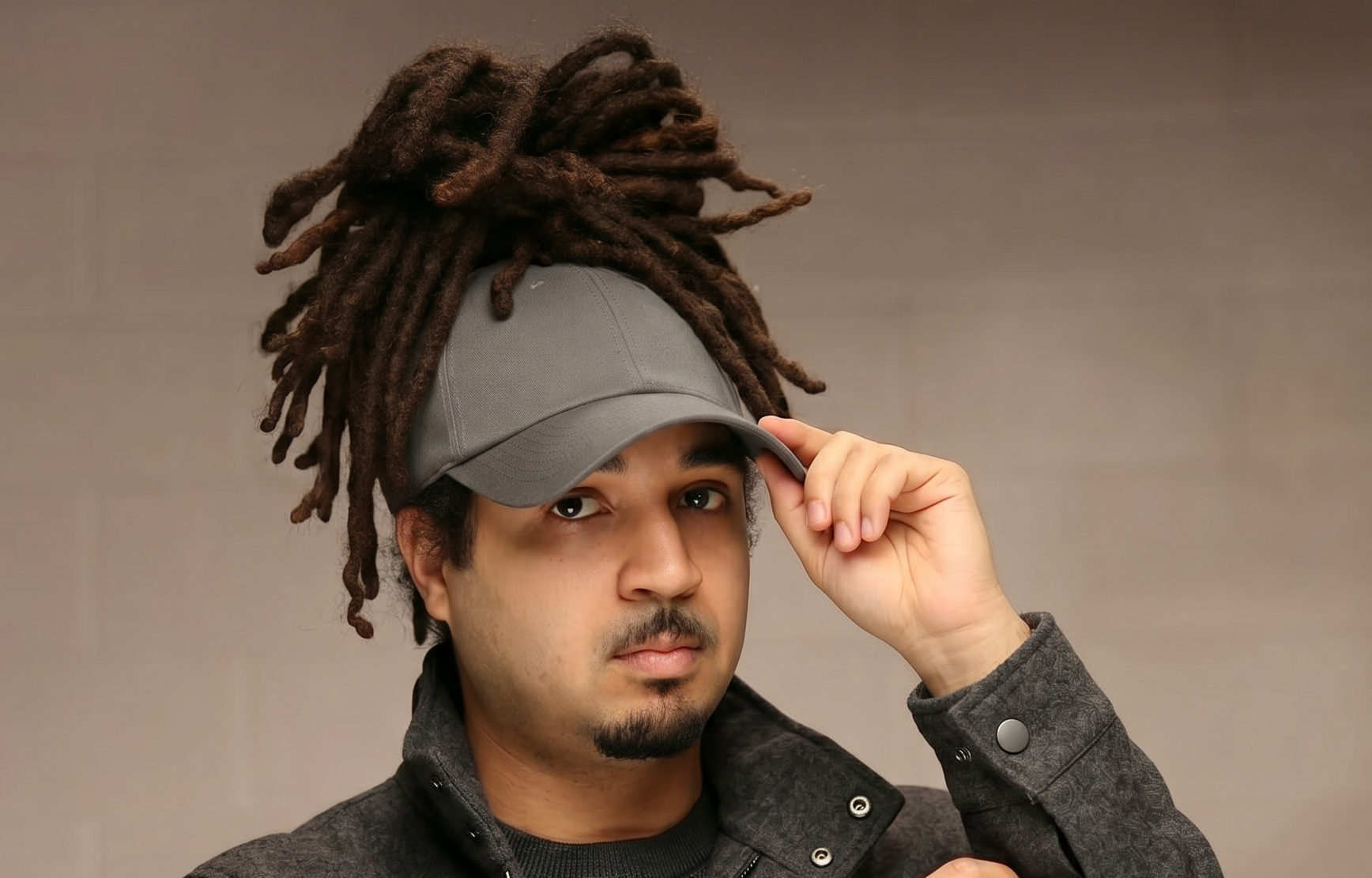 Model wearing a gray Rosebloom JAX with locs pulled through the crown opening, showing the hair-accommodating fit in a front-facing lifestyle portrait.