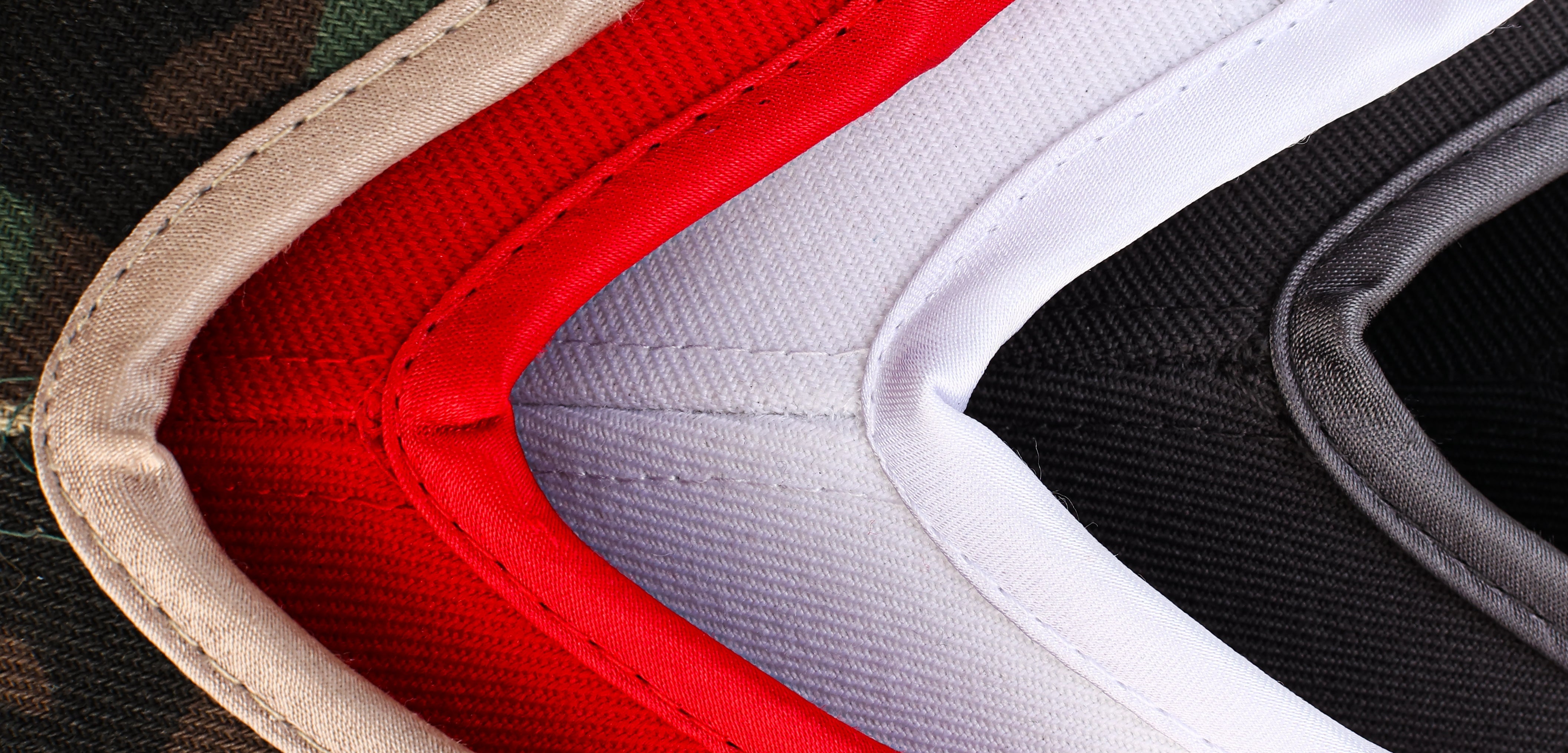 Close-up product detail of Rosebloom GZO crown openings in camo, red, white, and gray, highlighting the structured opening construction and fabric finish.