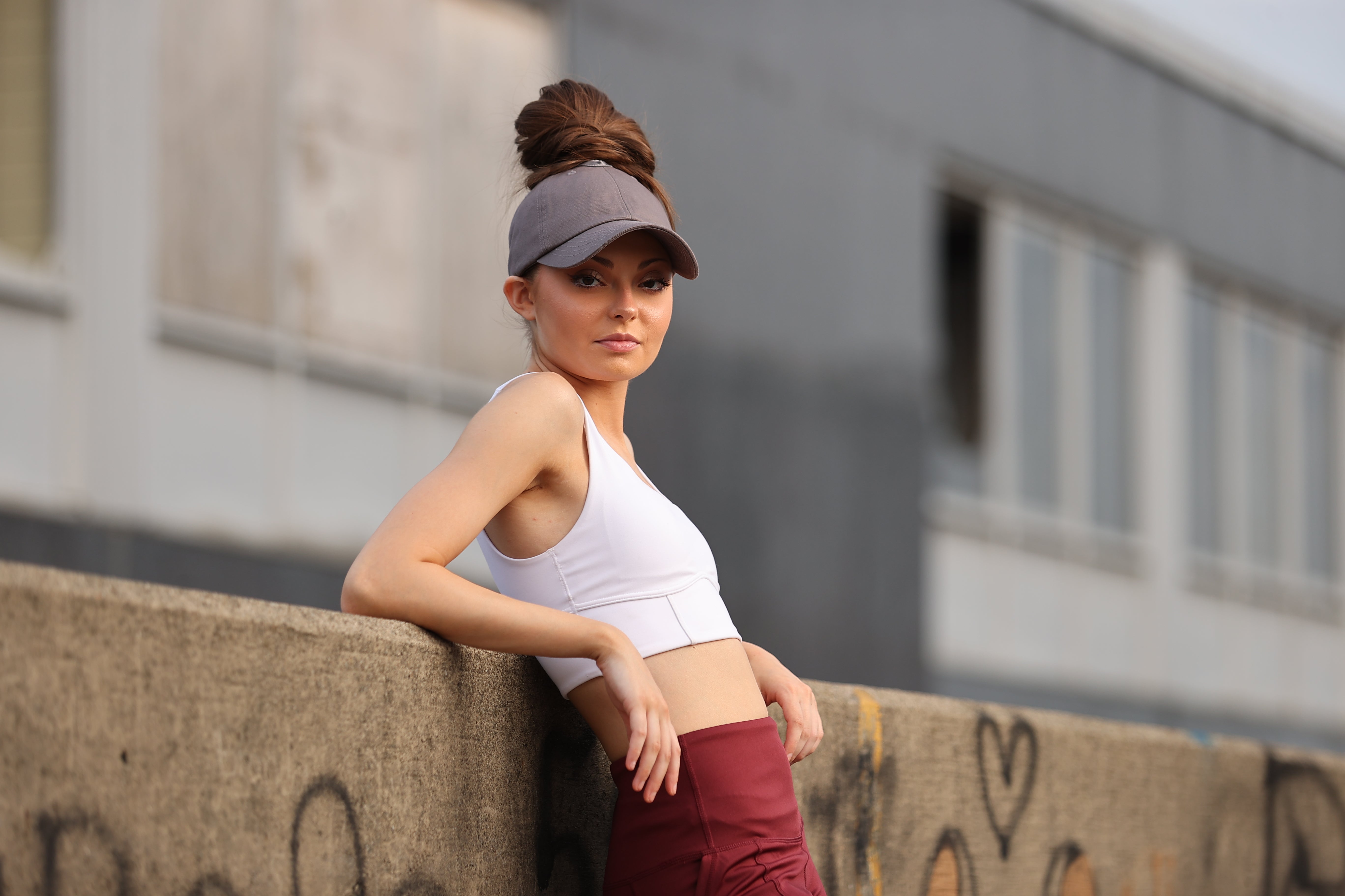 Woman wearing a gray Rosebloom PNT high ponytail hat with crown-height opening
