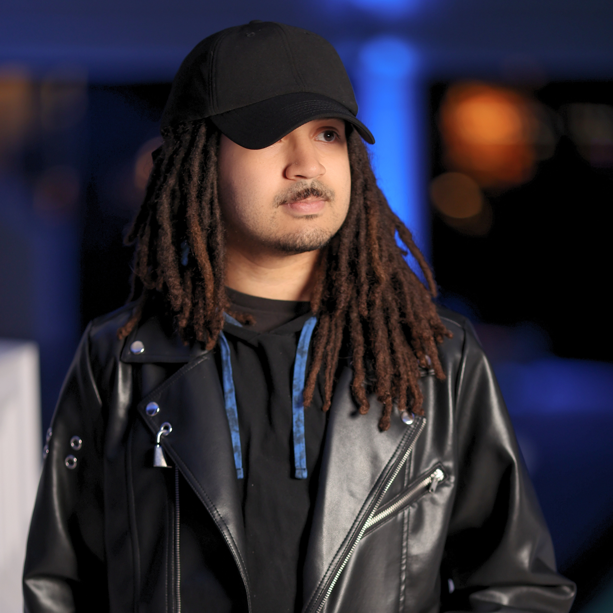 Model wearing the black Rosebloom HLO closed crown hat, showing room for locs, textured hair, and protective styles.