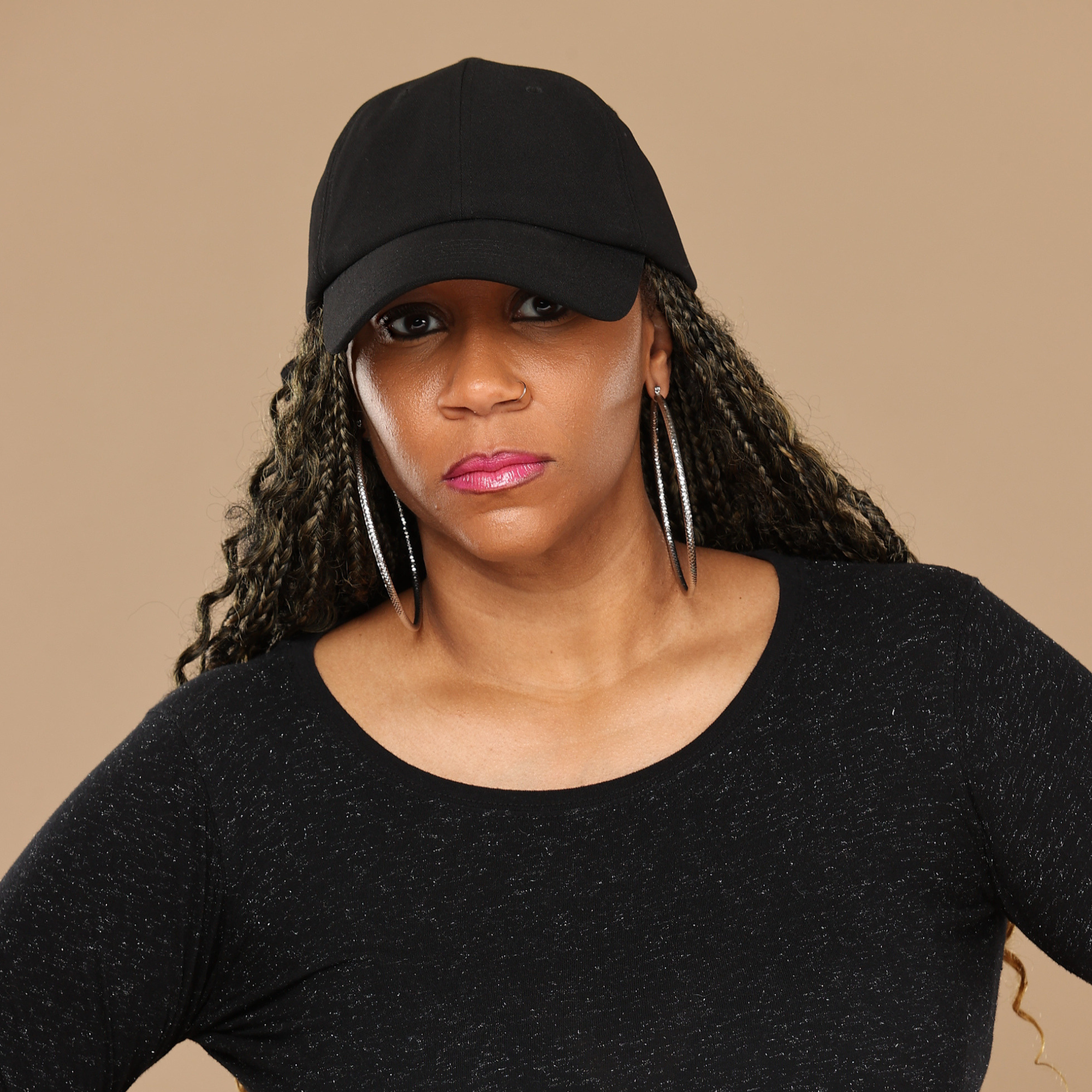 Model wearing the black Rosebloom HLO closed crown hat, showing room for locs, textured hair, and protective styles.