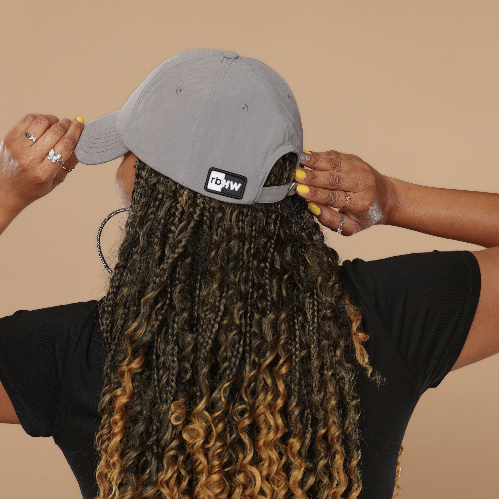 Model shown from behind wearing the gray Rosebloom HLO closed crown hat, showing room for locs, textured hair, and protective styles.