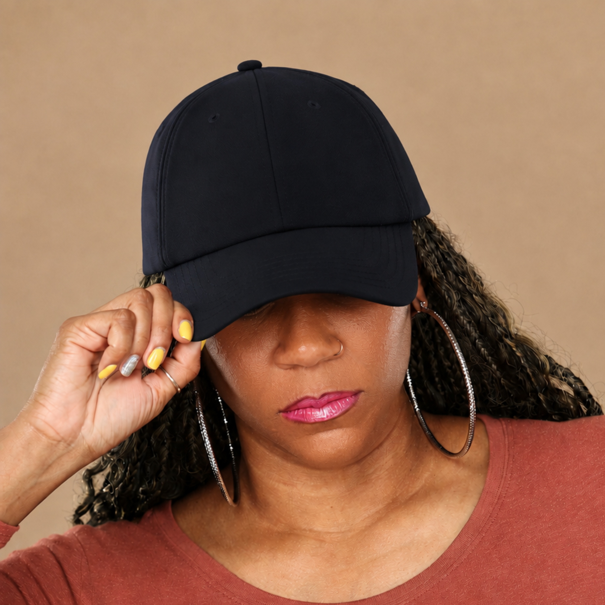 Model adjusting the bill of the navy Rosebloom HLO closed crown hat, showing room for locs, textured hair, and protective styles.