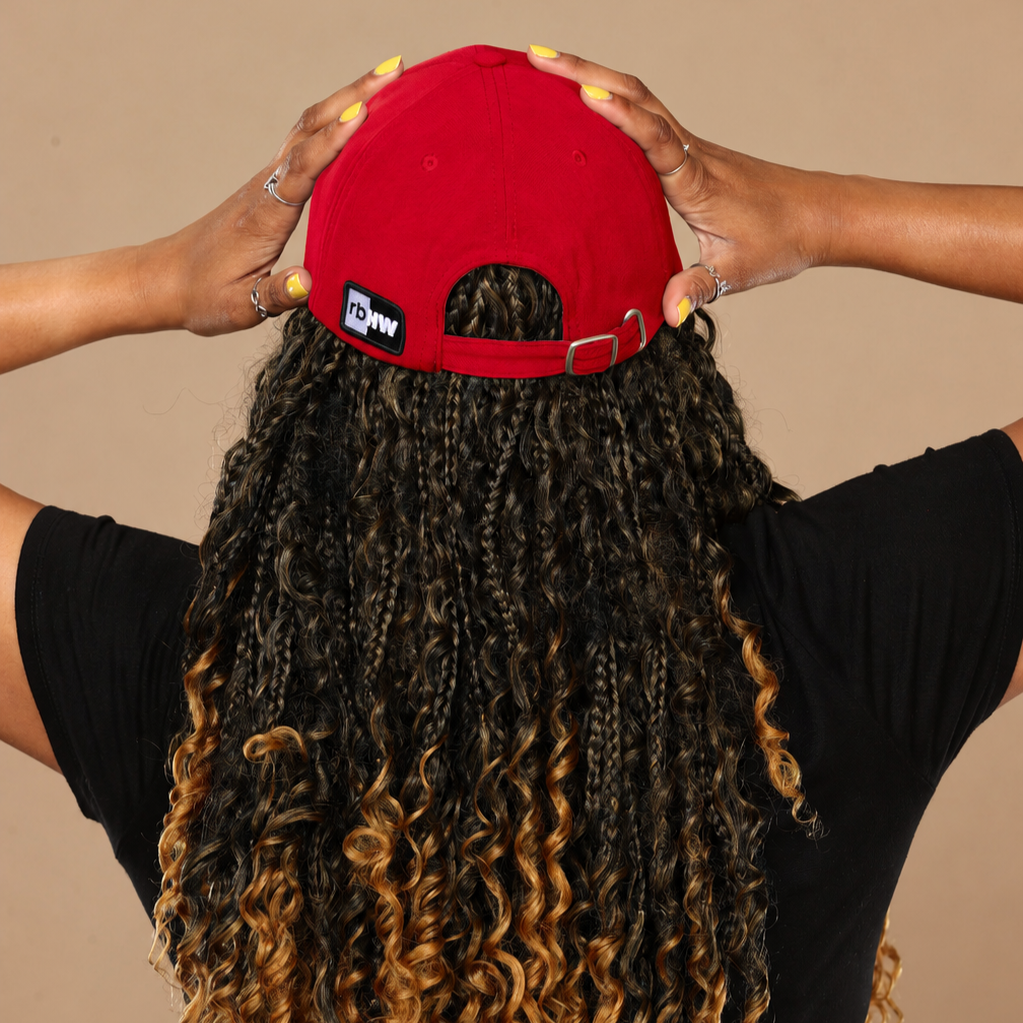 Model shown from behind wearing the red Rosebloom HLO closed crown hat, showing room for locs, textured hair, and protective styles.