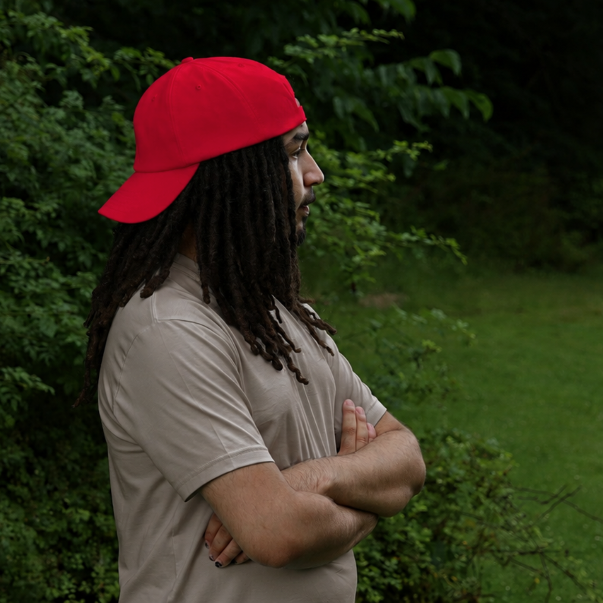 Model shown in profile wearing the red Rosebloom HLO closed crown hat, showing room for locs, textured hair, and protective styles.