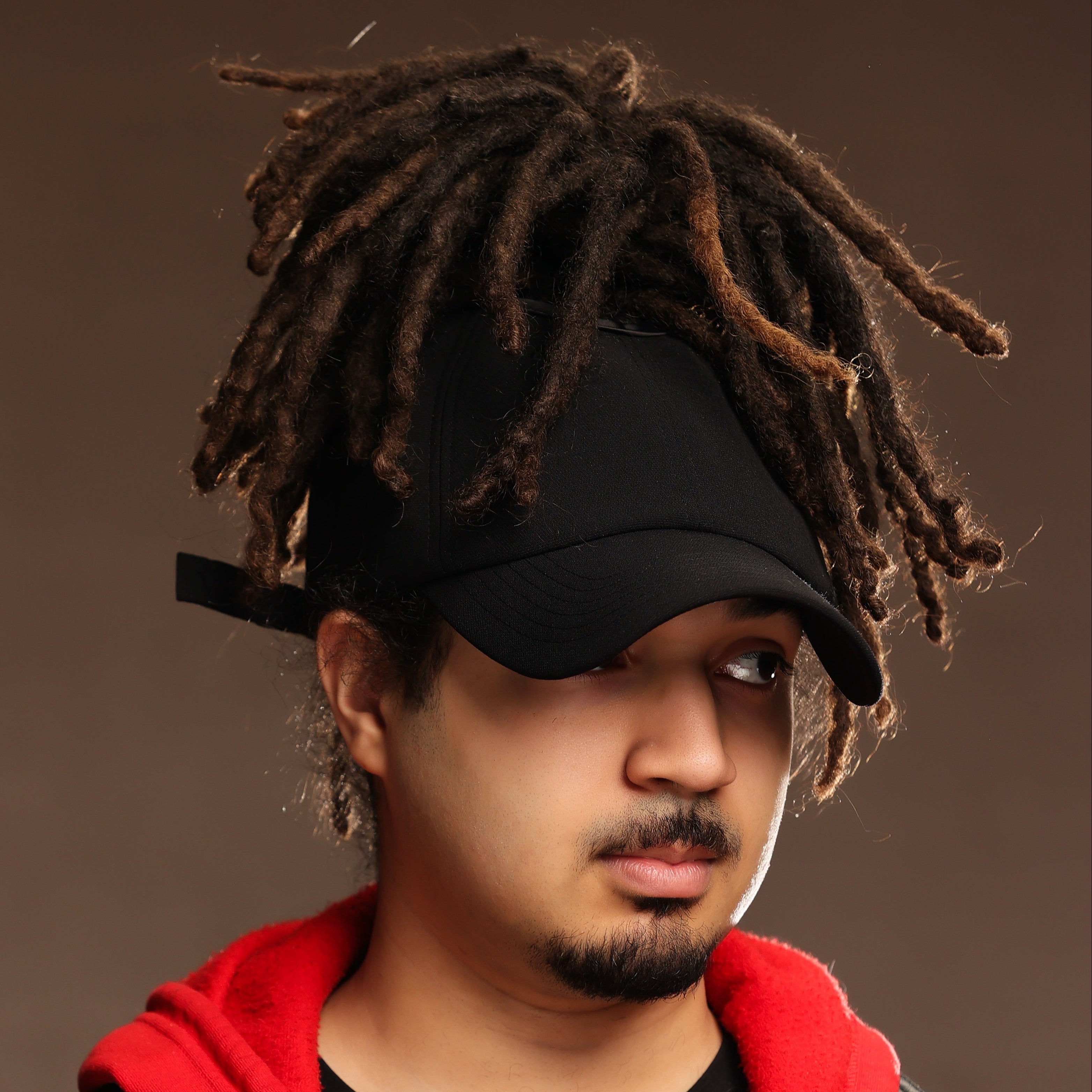 Model wearing the black Rosebloom JAX PETAL crown-height opening hat, showing room for locs, textured hair, and protective styles.