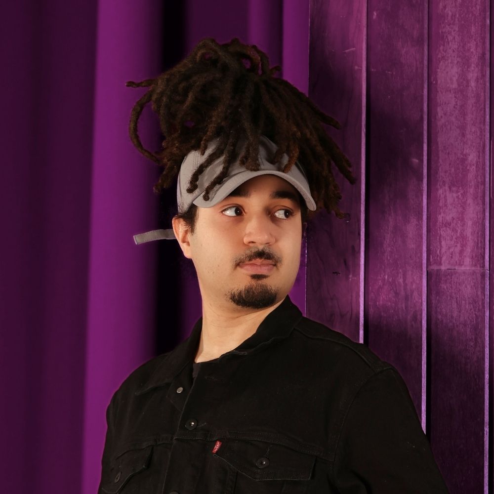 Model wearing the gray Rosebloom JAX PETAL crown-height opening hat, showing room for locs, textured hair, and protective styles.