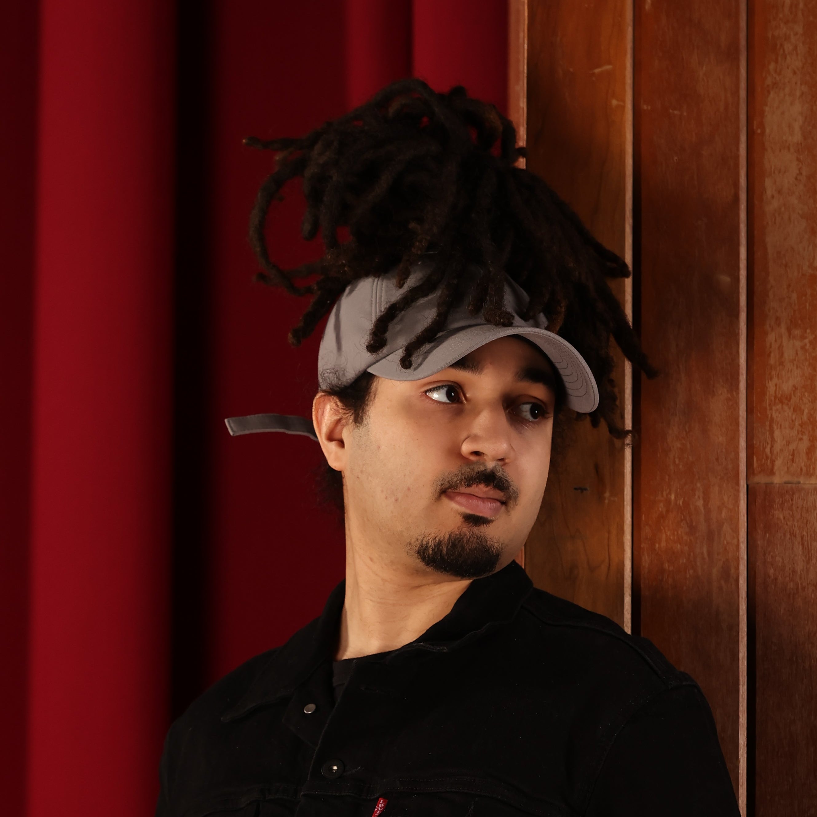 Model wearing the gray Rosebloom JAX PETAL crown-height opening hat, showing room for locs, textured hair, and protective styles.