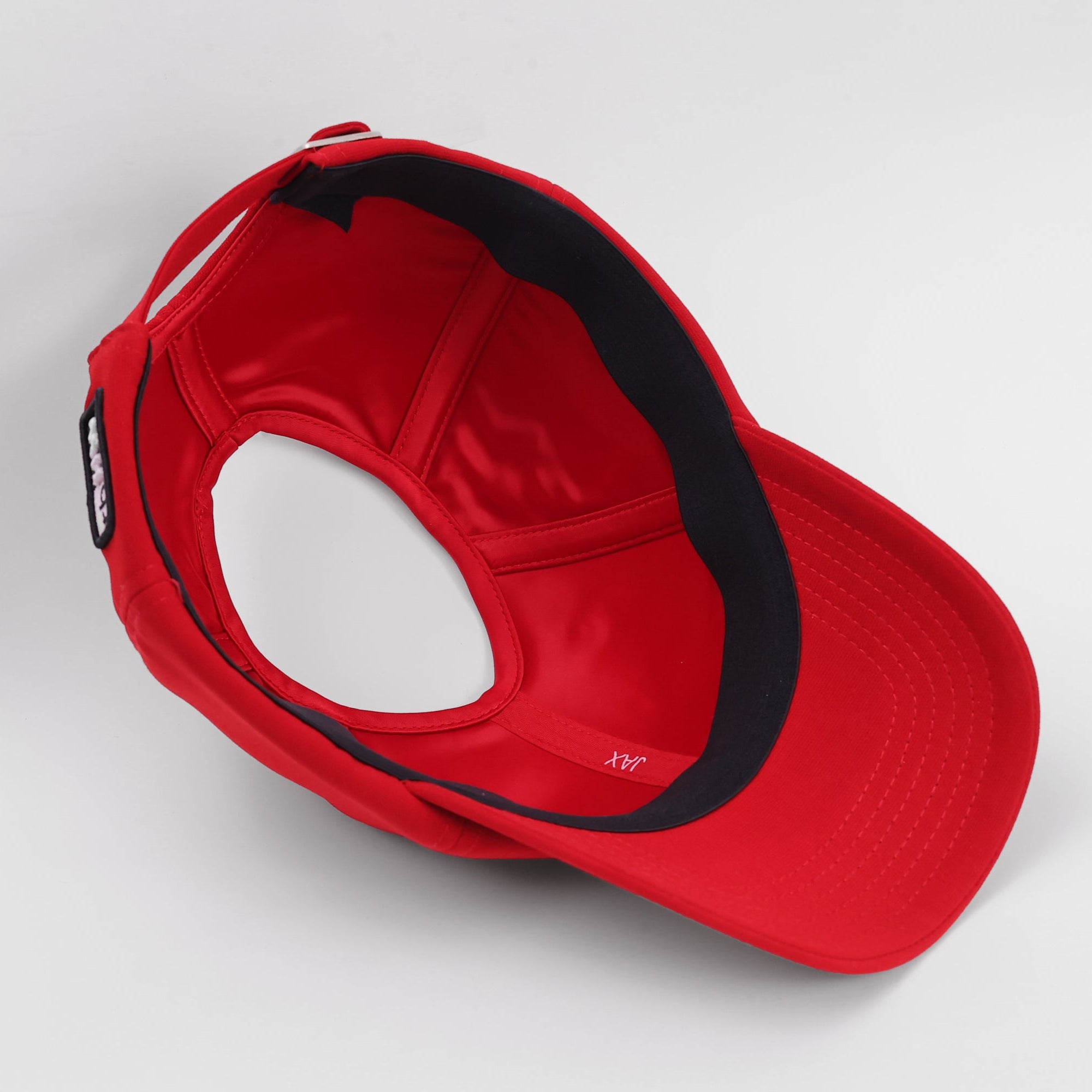 Interior view of the red Rosebloom JAX hat, showing its smooth satin lining and PETAL crown-height opening.