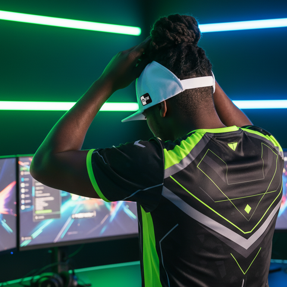 Lifestyle photo of a gamer wearing a white Rosebloom UEL GZO STRETCH hat with locs pulled through the crown opening in a neon-lit gaming setup.