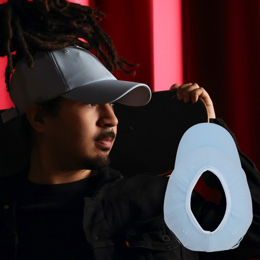 a young man with locs is wearing a well fitting satin lined baseball hat wit his locs pulled through the top in a ponytail. there is a picture of the hat showing the opening, which is large enough to accommodate a protective hairstyle like locs.