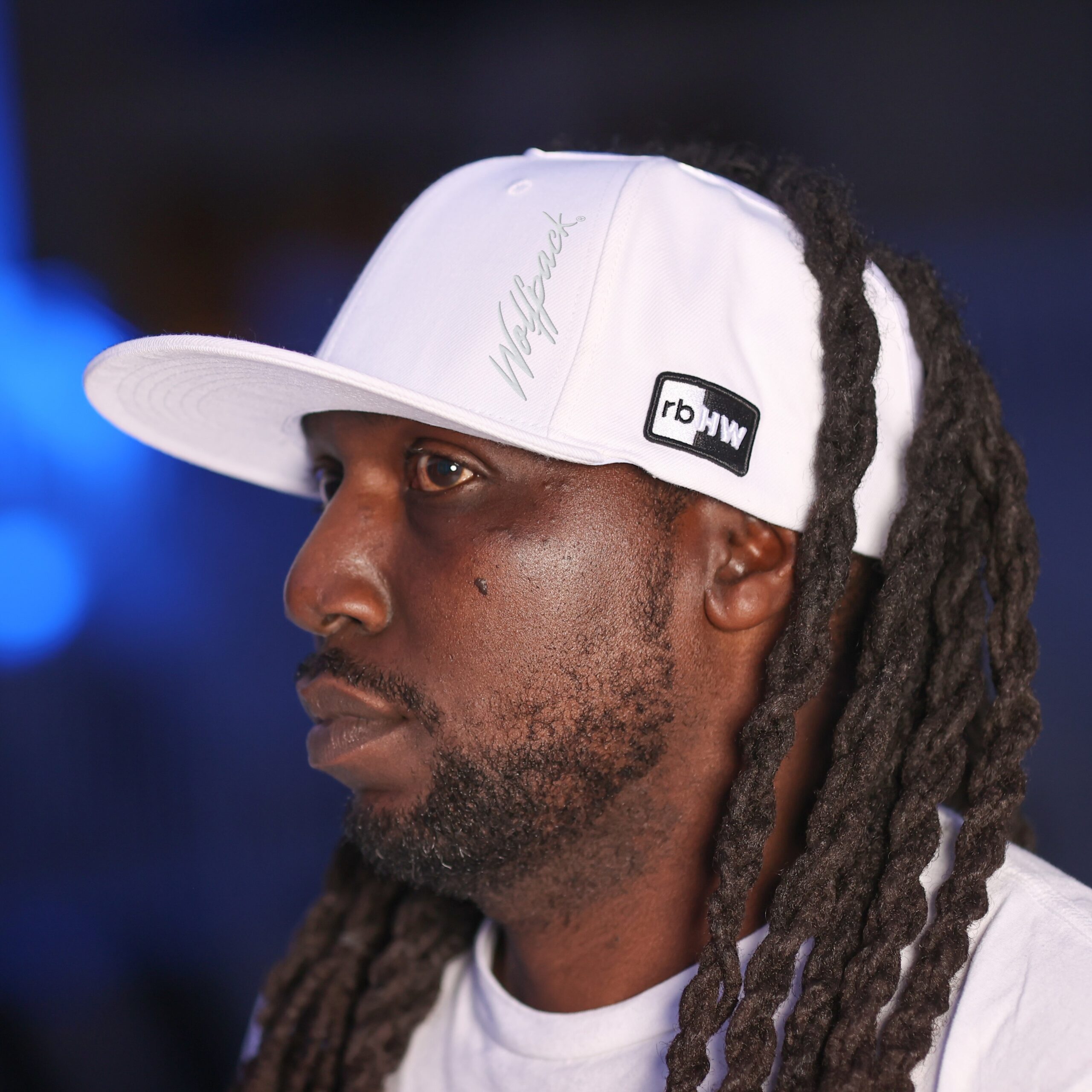 Black man wears satin lined NC State Wolfpack stretch fit ponytail baseball hat for locs and textured hair