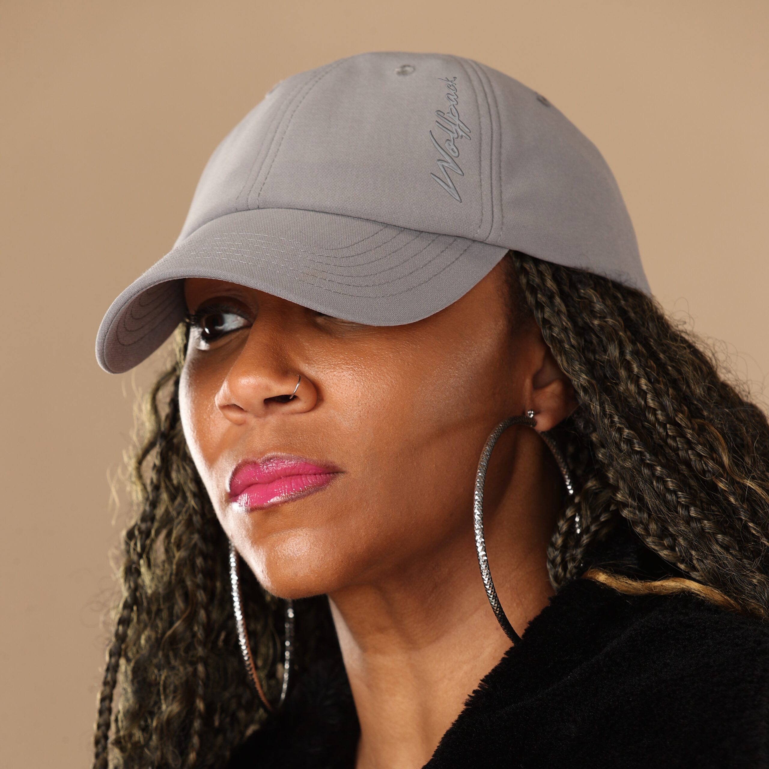 Black woman wearing satin lined NC State Wolfpack hat for thick hair