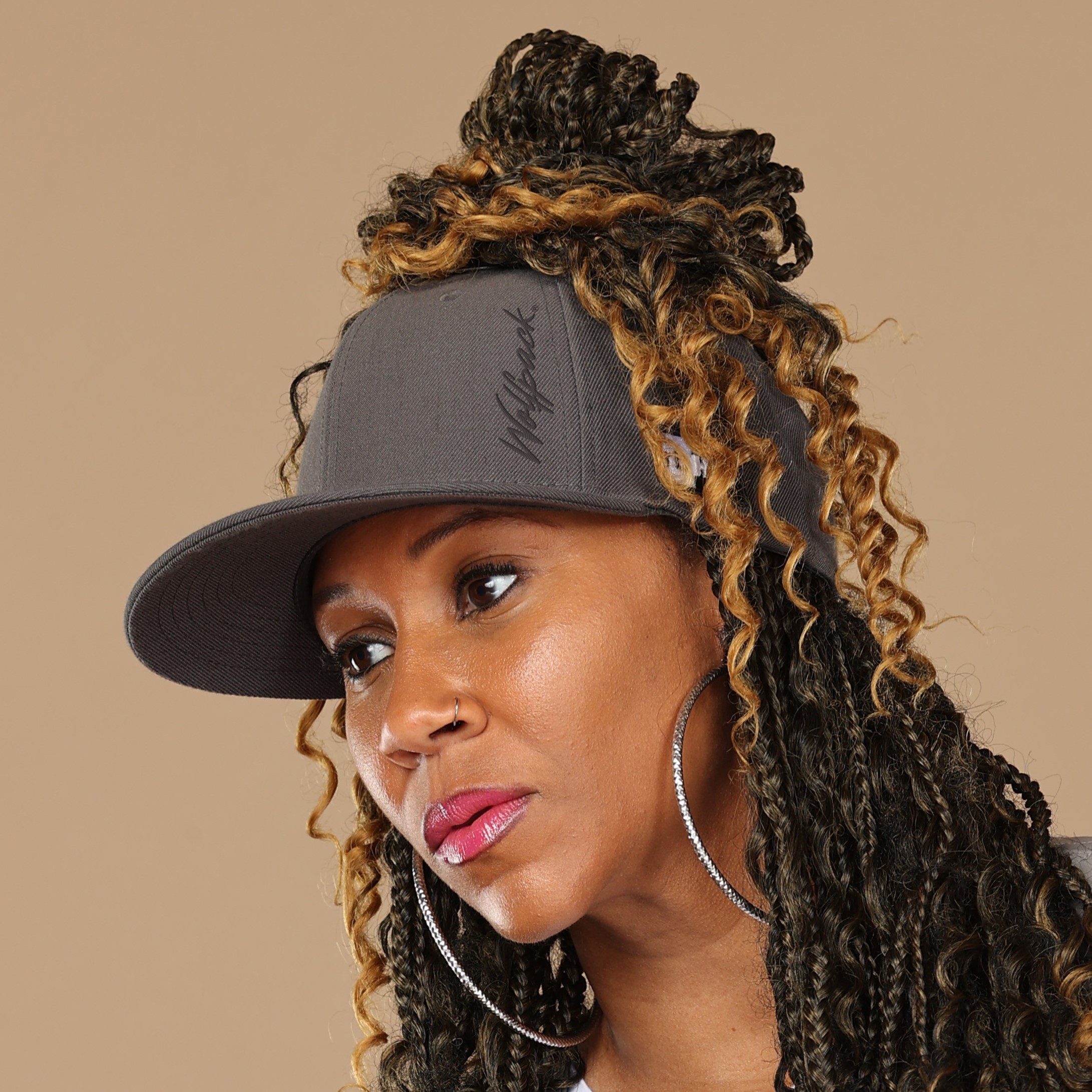 Black woman wears satin lined NC State Wolfpack stretch fit ponytail baseball hat for locs and textured hair
